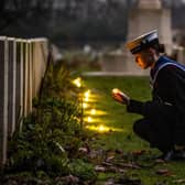 Sea Cadet Lucia Leeming-Sheppard places candles at Canadian Air Force graves during a Candlelit Christmas Remembrance at the Commonwealth War Graves at Stonefall Cemetery, Harrogate
