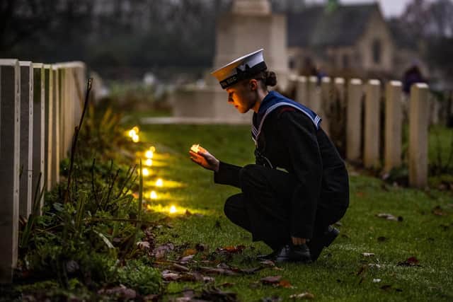 Sea Cadet Lucia Leeming-Sheppard places candles at Canadian Air Force graves during a Candlelit Christmas Remembrance at the Commonwealth War Graves at Stonefall Cemetery, Harrogate