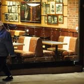 A man passes the window of an empty restaurant in central London