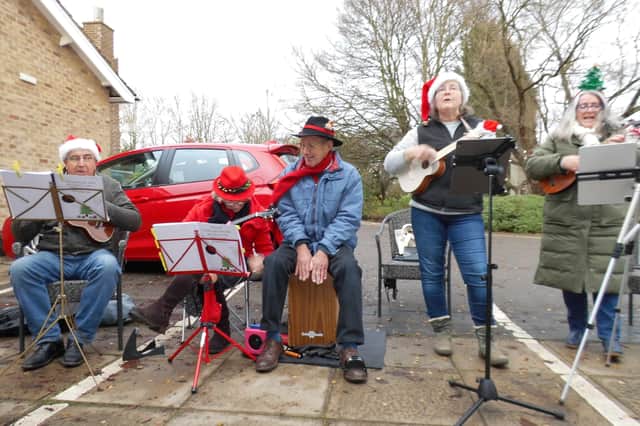 Ukulele players perform carols in the grounds at Wold Haven Care Home.