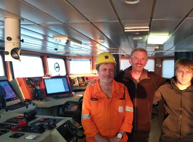 Chris Pearsall, pictured with captain and crew aboard the Ukrainian cargo ship that came to his rescue. Image supplied.