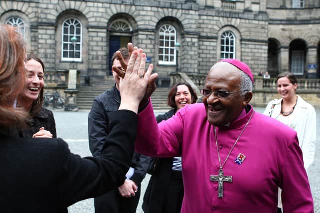 The late Desmond Tutu giving high fives to waiting students after an honorary degree ceremony at Edinburgh University Andrew Milligan/PA Wire