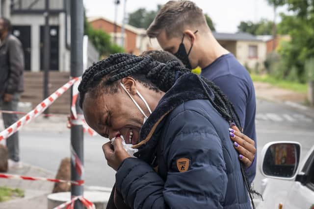 A woman weeps outside the historical home of Anglican Archbishop Desmond Tutu, in Soweto, Johannesburg, South Africa, on December 27.