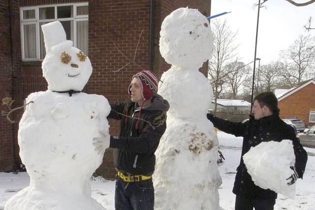 Karl Leveridge (left) and Marcus Norton building a snowman and snowwoman.