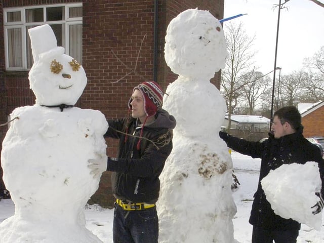 Karl Leveridge (left) and Marcus Norton building a snowman and snowwoman.