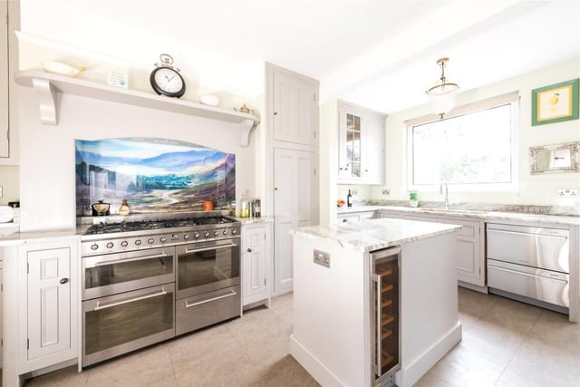 The kitchen/breakfast room blends modern custom built units with older traditional built-in storage cupboards, including glazed display cabinets and a central island unit with fitted drawers. There are granite work surfaces and space and plumbing for a variety of freestanding appliances