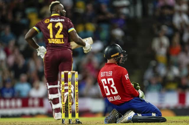 FIRST DOWN: England's captain Jos Buttler sinks to his kneels as West Indies' all-rounder Andre Russell scores runs during the first T20 cricket match at Kensington Oval in Bridgetown, Barbados. Picture: AP/Ricardo Mazalan