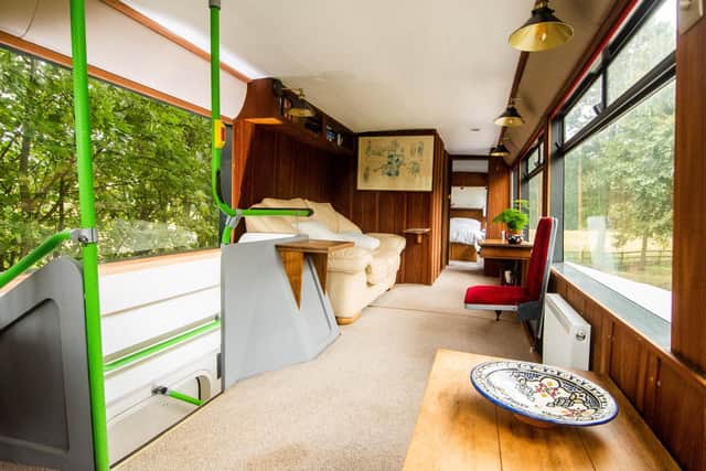 The living space on the top deck is very spacious and includes sitting areas, original bus seats, a TV and a desk plus a double bedroom and shower
