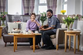 Colleague and resident at HC-One care home enjoying cup of coffee and slice of cake