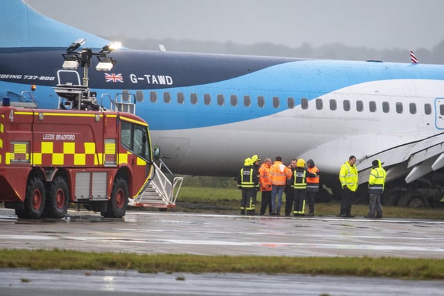 Fre crews and staff by a  Tui plane which has slipped off the runway at Leeds Bradford Airport
