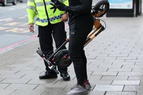 An e-scooter rider being stopped by a police officer. PIC: Yui Mok/PA Wire
