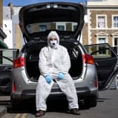 Uber driver Yasar Gorur wears personal protective equipment while cleaning his vehicle (Photo: Hollie Adams/Getty Images)