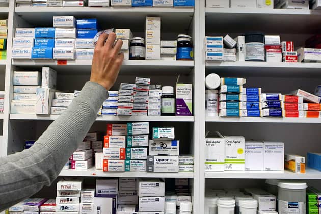 A pharmacist stocking shelves at a chemist. PIC: PA