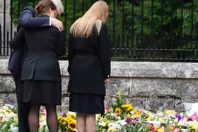 The Duke of York, Princess Eugenie and Princess Beatrice (right) view the messages and floral tributes left by members of the public Balmoral in Scotland following the death of Queen Elizabeth II on Thursday.