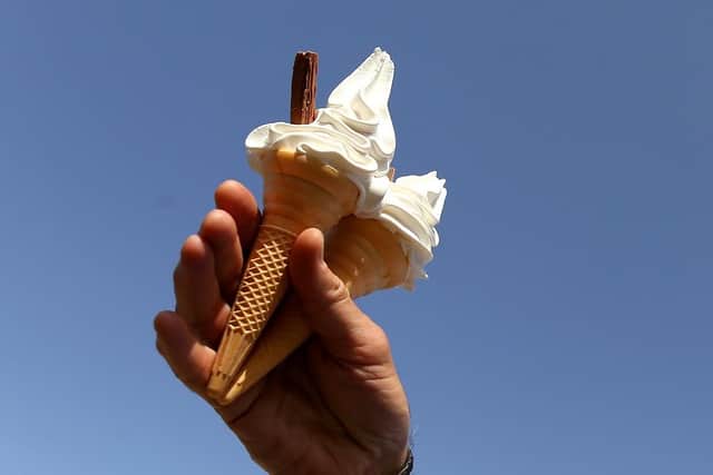 A spectator holds up two ice creams. (Pic credit: Stephen Pond / Getty Images)