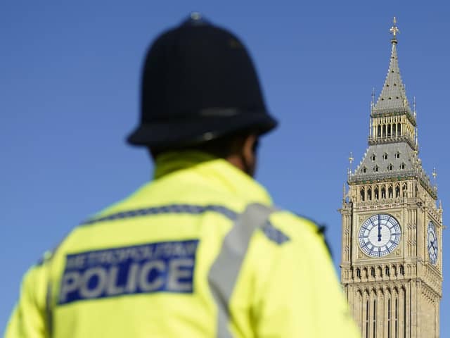 Elizabeth Tower, part of the Palace of Westminster and a Metropolitan Police officer in Parliament Square, London. PIC: Andrew Matthews/PA Wire