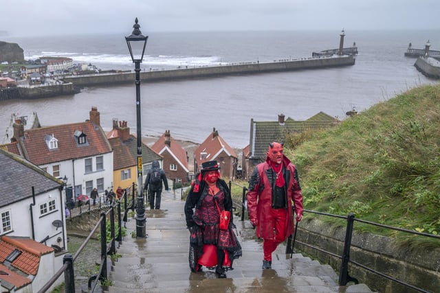 Two people dressed in devil costumes walking up the 199 steps.