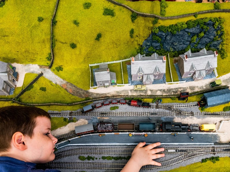 Tommy Morley, aged 8, admiring his 00 & 009 gauge layout titled 'Oxford East' fictional scene in North Wales.
