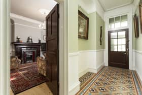 The hall floor in period tiles and a glimpse into the sitting room