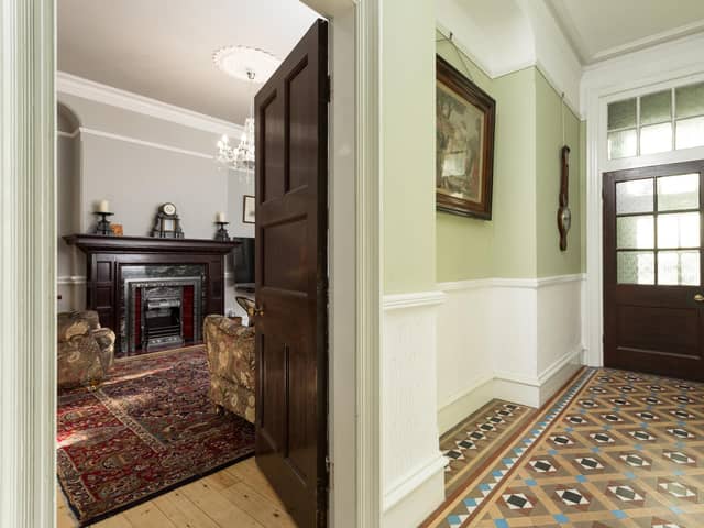 The hall floor in period tiles and a glimpse into the sitting room