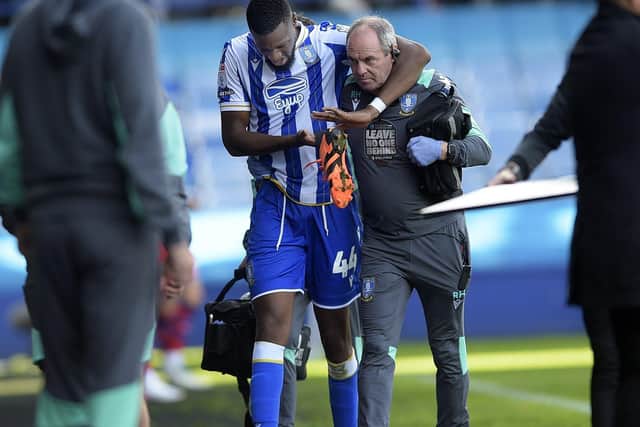 Sheffield Wednesday midfielder Momo Diaby leaves the field during the second half on Saturday with the help of Doctor Richard Higgins. Picture: Steve Ellis.
