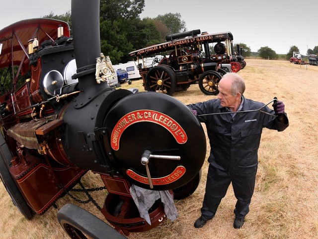 A traction engine owner polishes his immaculately restored John Fowler engine before the day's displays get underway