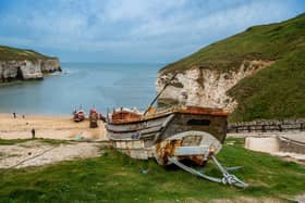 The remains of a old fishing Yorkshire Coble looks across the beach at North Landing at Flamborough, East Yorkshire.
