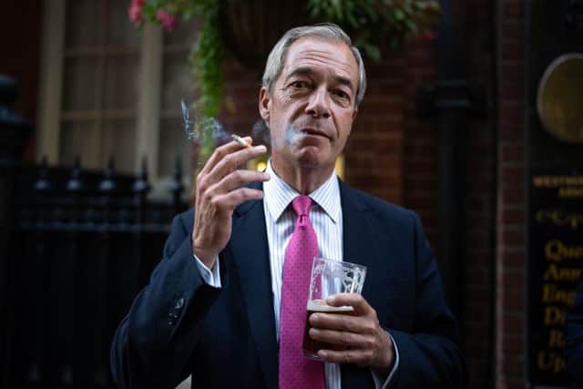 Reform UK leader Nigel Farage smokes a cigarette and drinks a pint of ale outside a pub on August 29, 2024 in London(Photo by Carl Court/Getty Images)