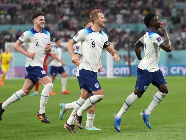 England's Bukayo Saka (right) celebrates scoring their side's fourth goal of the game during the FIFA World Cup Group B match at the Khalifa International Stadium in Doha,with Iran (Picture: Martin Rickett/PA)