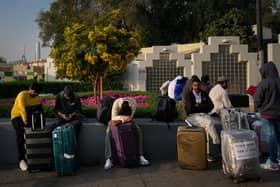 Passengers stranded by the closure of Dubai International Airport await for assistance in the airport parking lot in Dubai, United Arab Emirates on Sunday