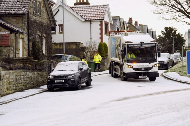 Refuse collectors clears the bin in snowy conditions in Briggswath, North Yorkshire. (Photo credit: Owen Humphreys/PA Wire)