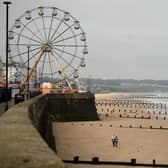 People walk along an empty beach in Bridlington. (Pic credit: Oli Scarff / AFP via Getty Images)