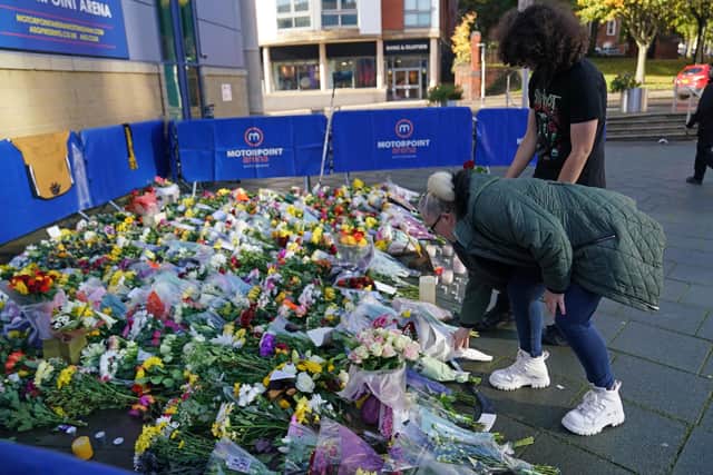People lay flowers and messages in tribute to Nottingham Panthers' ice hockey player Adam Johnson outside the Motorpoint Arena in Nottingham, the home of the Panthers