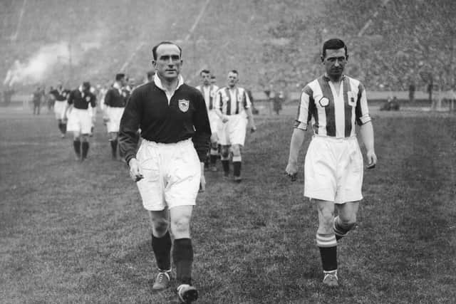 Captains Tom Parker and Tommy Wilson leading out Arsenal and Huddersfield Town for the FA Cup Final at Wembley, 26th April 1930. Arsenal won the match 2-0. (Photo by Central Press/Hulton Archive/Getty Images)