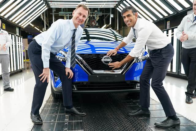 Prime Minister Rishi Sunak and Chancellor of the Exchequer Jeremy Hunt attach a Nissan badge to a car as they visit the car manufacturer Nissan on November 24, 2023 in Sunderland, England. The Prime Minister and Chancellor visit the Japanese car manufacturer as they announce they will be building three new electric car models at its plant in Sunderland as part of a £2bn investment.  (Photo by Ian Forsyth/Getty Images)