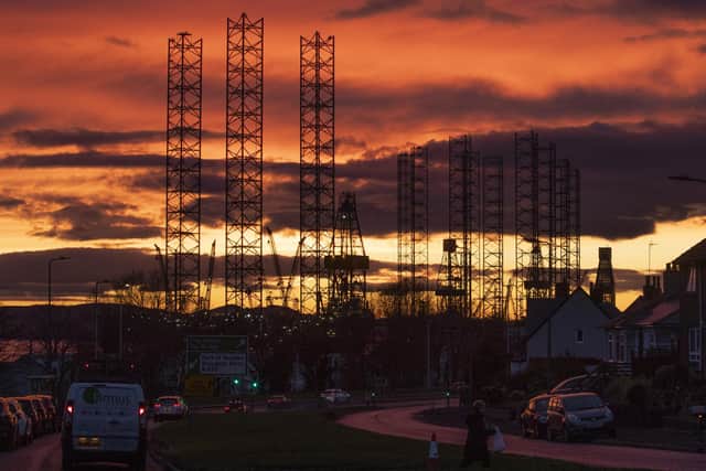 Jackup rigs, used in the North Sea oil and gas industry, are silhouetted against the sky at sunset over the Port of Dundee in the Firth of Tay, Dundee.