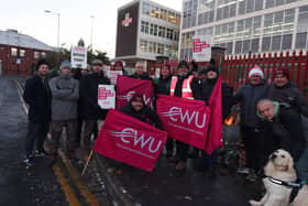 Members of the Communications Workers Union (CWU) and supporters picket outside a Royal Mail office.