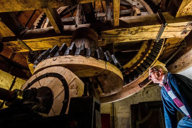 Chris Tippin one of the volunteers at Holgate Windmill, looking at the break wheel just below the cap of the mill. Picture By Yorkshire Post Photographer,  James Hardisty