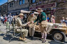 Carl Holmes, Andy Gallacher and Sarah Linley have a chat by a WWII African desert RAF Jeep at the 1940s Weekend in Haworth