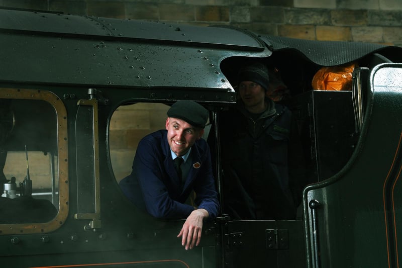 The train driver of the Royal Scot looks out as the train takes off again.