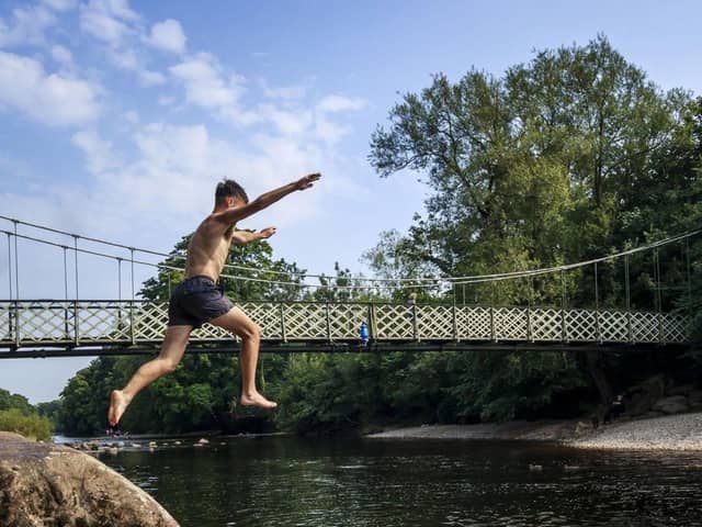 A swimmer jumps into the River Wharfe in Ilkley