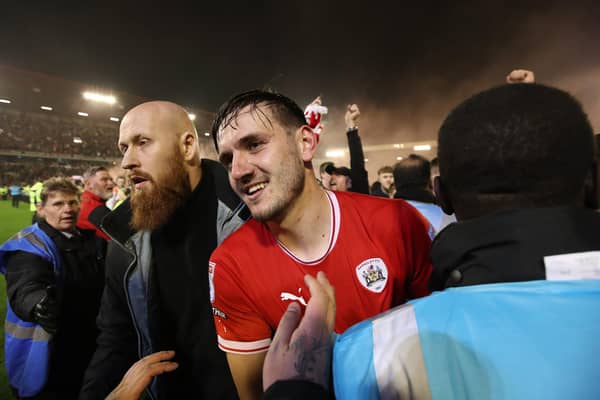 Mobbed: Liam Kitching of Barnsley is escorted by stewards as he celebrates with fans on the pitch after the play-off win over Bolton (Picture: George Wood/Getty Images)