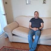 Darren Leeming, 54, sits on a couch he got for free from Facebook Marketplace.