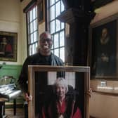 Photographer Ashley Karrell installs the new portrait of Dr Delma Tomlin, the first woman to be appointed Governor of York's Merchant Adventurers’ Hall.