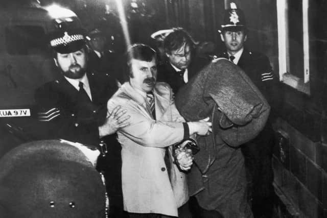 His head covered with a blanket, Peter Sutcliffe, aka 'The Yorkshire Ripper', is escorted into Dewsbury Magistrates Court to be charged with murder, 6th January 1981. (Photo by Jack Hickes/Keystone/Hulton Archive/Getty Images)