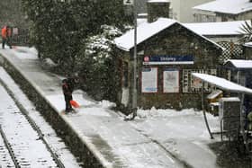 Snow is cleared from the platform at Shepley Railway Station.