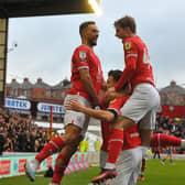 Barnsley's first goalscorer Nicky Cadden, who was later sent off, is mobbed by Adam Phillips and Luca Connell after scoring against Shrewsbury. Picture: Steve Riding.