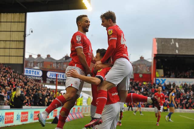 Barnsley's first goalscorer Nicky Cadden, who was later sent off, is mobbed by Adam Phillips and Luca Connell after scoring against Shrewsbury. Picture: Steve Riding.