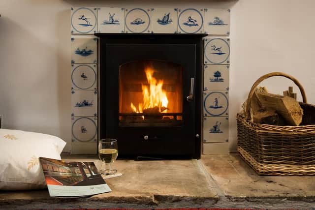 The fireplace with wood-burning stove now has a surround featuring antique Delft tiles