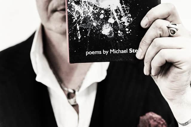 Author Michael Stewart and his latest poetry collection The Dogs. Picture: Paul Crowther